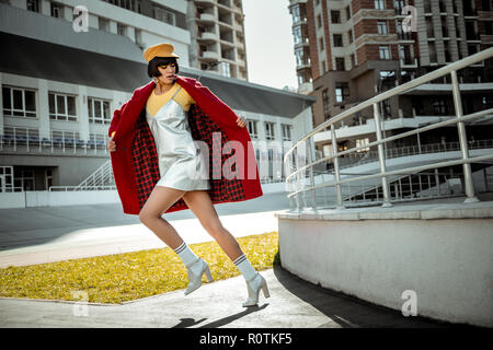 Beautiful dark-haired woman unrealistically stepping with her white shoes Stock Photo