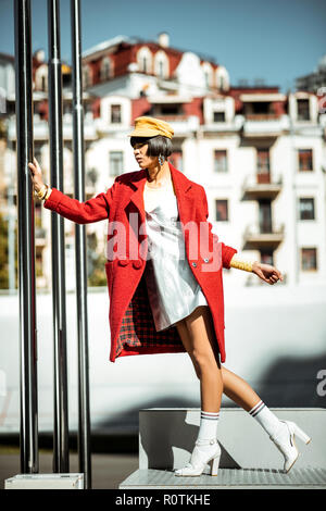 Attracting authentic girlfriend elegantly posing with silver pipes nearby Stock Photo