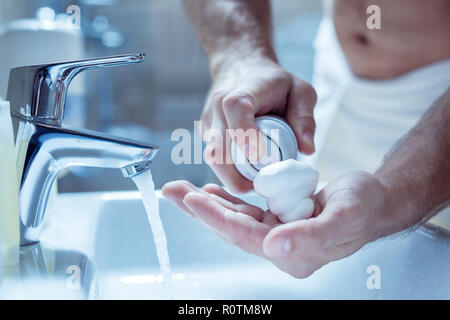 Top view of male hands using shaving foam after taking shower Stock Photo