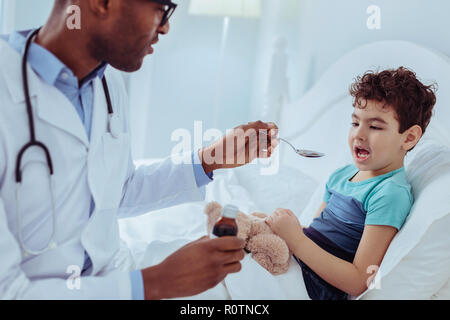 Pleasant nice ill boy opening his mouth Stock Photo