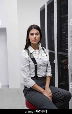 Technician apecialist woman using laptop while analyzing server in server room Stock Photo