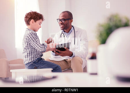 Nice joyful boy talking to his doctor Stock Photo