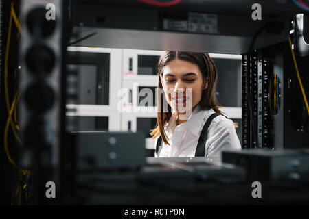 Technician apecialist woman using laptop while analyzing server in server room Stock Photo