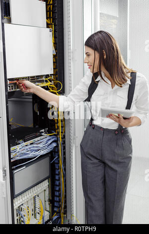 Technician examining server in server room Stock Photo