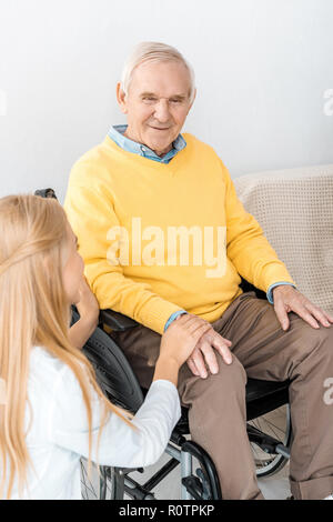 female doctor holding disabled senior patient hand in clinic Stock Photo