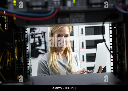 Technician examining server in server room Stock Photo
