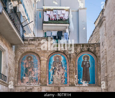 Laundry drying above medieval frescoes on Church of San Marco dei Veneziani, in historic center of Bari, Apulia, Italy Stock Photo