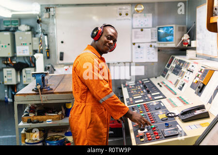 Marine engineer officer in engine control room ECR. Seamen's work. He starts or stops main engine of ship Stock Photo