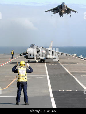 HARRIER of No 1 (F) Squadron RAF  landing on in board HMS Illustrious whilst another waits its turn during Exercise Joint Warrior in 2008.Photo: Cpurtesy MOD 45149691. Stock Photo