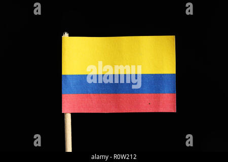 A national flag of colombia on toothpick on black background. A horizontal tricolour of yellow, blue and red Stock Photo