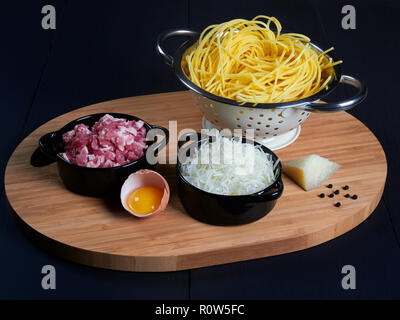 Ingredients for spaghetti carbonara: fresh spaghetti, grated pecorino romano, bacon (or guanciale), egg yolk, black peppercorns Stock Photo