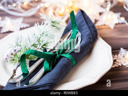 Christmas table setting with cutlery, napkin and ribbon, festive table decorations, closeup Stock Photo