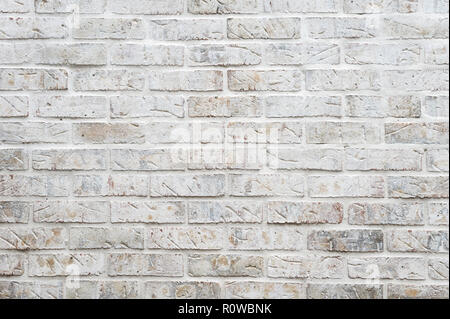 White painted brick wall full frame background with gritty textured imperfections Stock Photo