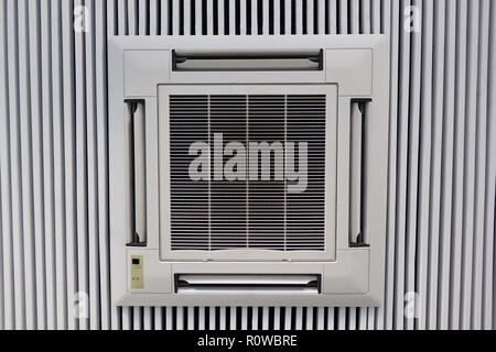 White air conditioner attached to white wood planks ceiling. Office air circulation concept Stock Photo