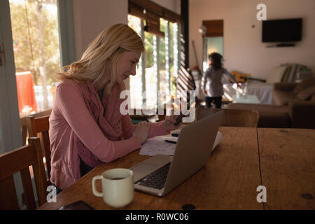 Woman using mobile phone at home Stock Photo