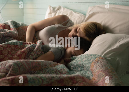 Mother and daughter sleeping in bedroom Stock Photo
