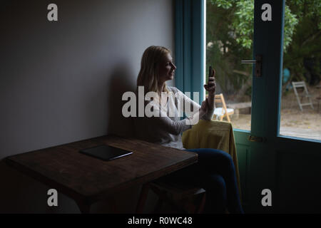 Woman using mobile phone at home Stock Photo