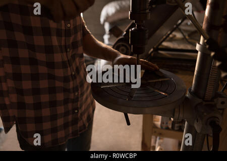 Female metalsmith using radial drilling machine in factory Stock Photo