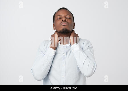 I need a massage. Frustrated african man holding hand on his neck Stock Photo