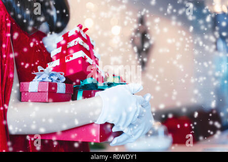 Merry Christmas concept. Santa holding gift boxes with falling snow. Stock Photo