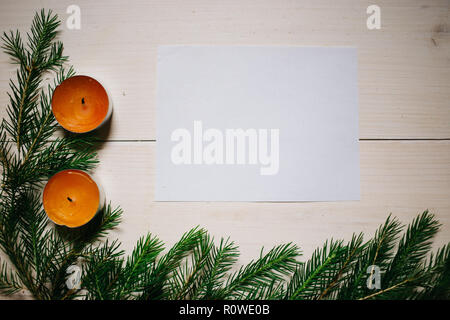 Christmas composition. Christmas gift, two candles, fir branches on wooden white background, Stock Photo