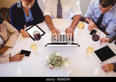 Business people using multimedia devices in restaurant Stock Photo