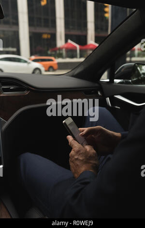 Businessman using mobile in car Stock Photo