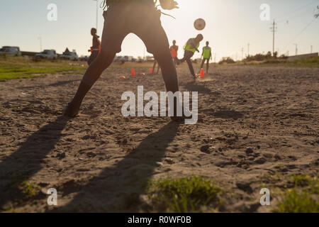 Kids playing football in the ground Stock Photo