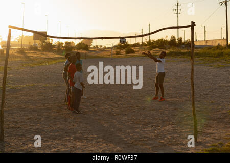 Kids playing with football in the ground Stock Photo