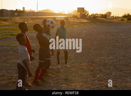 Kids playing with football in the ground Stock Photo