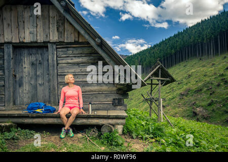 Young woman hiker camping and looking at beautiful view in Tatra mountains on hiking trip. Inspirational landscape in Poland. Active girl resting outd Stock Photo