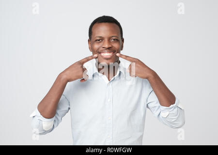 African young handsome man showing his excellent white teeth. Stock Photo
