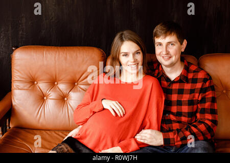 Cheerful couple sitting on sofa Stock Photo