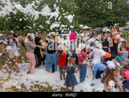 Kamennomostsky, Russia - September 1, 2018: Happy children having fun at a foam party at a holiday town day in an autumn park Stock Photo
