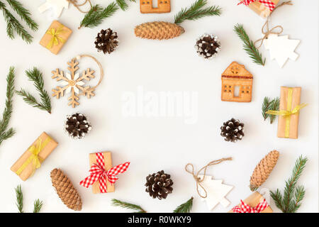 Christmas composition. Frame made of white and wood decor, cones, branches, cookies on white. Flat lay, copy space Stock Photo
