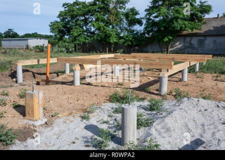 Pine wooden frame house foundation on screw piles, construction site. Construction stages of the A-type frame house Stock Photo