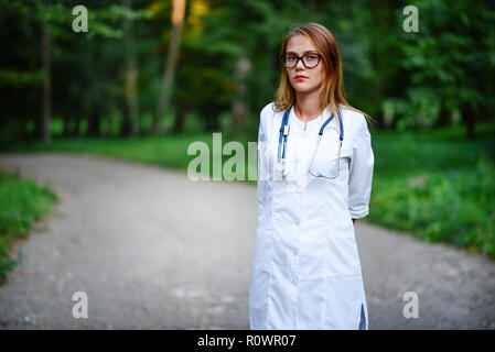 a young girl who is a doctor stands outside, she has crossed her arms on her chest. Stock Photo