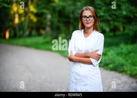 a young girl who is a doctor stands outside, hands are crossed on the stomach. Stock Photo