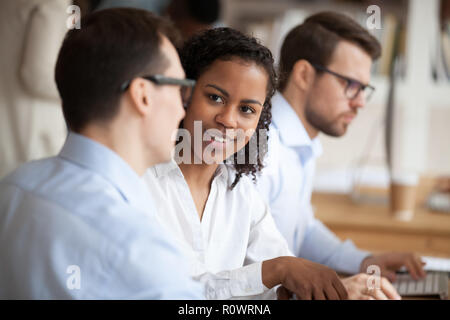 Multiracial employees talk working together in shared office Stock Photo