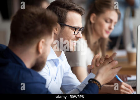 Close up of male colleagues laugh working at pc  Stock Photo