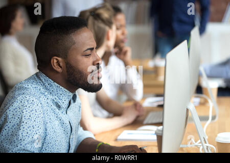 Thoughtful African American look at computer screen working Stock Photo