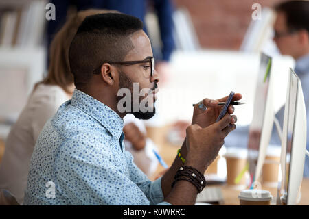 African American male worker using smartphone at work Stock Photo