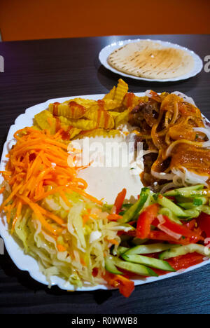 Shaverma, plate of lamb kebab with fries and salad, Saint Petersburg, Russia Stock Photo