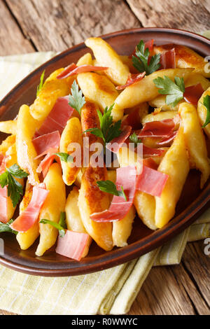 German cuisine. Fried schupfnudeln with ham and herbs close-up on the table. vertical Stock Photo