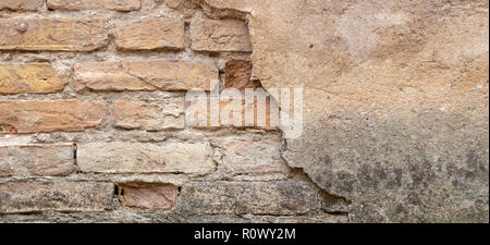 Old brick wall with peel stucco texture. Retro vintage worn wall background. Decayed cracked rough abstract wall surface Stock Photo