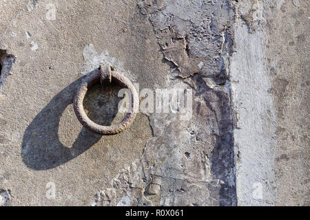 Old iron hoop hanging from stone wall Stock Photo