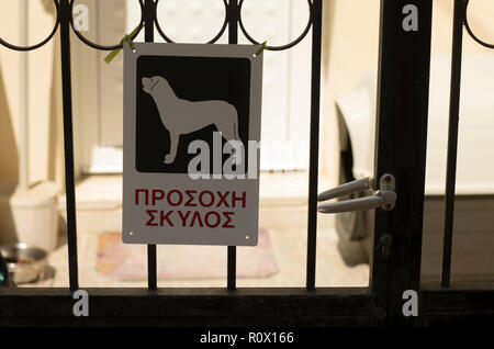 Warning sign 'Beware of dog' with the inscription in Greek on the island Crete Stock Photo