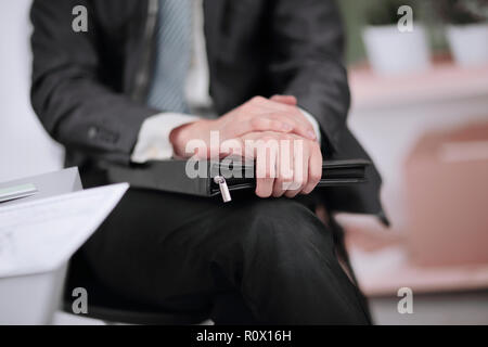 close up.A businessman with a leather briefcase sitting in an of Stock Photo