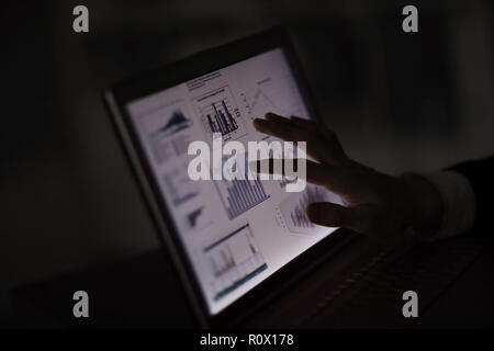 close up.Businessman pointing finger at laptop screen with financial chart Stock Photo