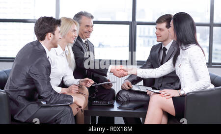 employees look at the handshake of business partners Stock Photo